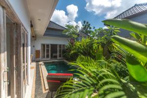 einen Pool im Hinterhof eines Hauses mit Pflanzen in der Unterkunft Castro Villa in Seminyak