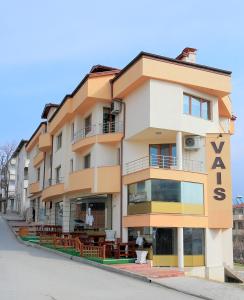 um edifício alto com mesas à frente em Къща за гости "ВАИС" em Sandanski