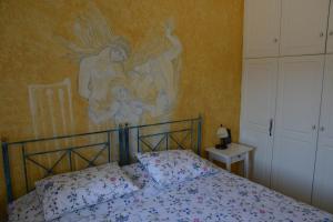 アギオス・イオアニスにあるTinos Porto Villasのベッドルーム1室(壁に絵画が描かれたベッド1台付)