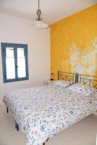アギオス・イオアニスにあるTinos Porto Villasのベッドルーム1室(壁に絵画が描かれたベッド1台付)