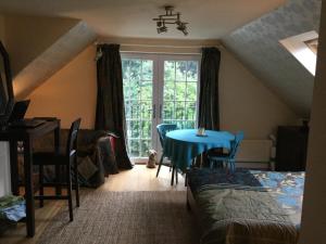 a room with a blue table and chairs and a window at Hurstbourne in Camberley