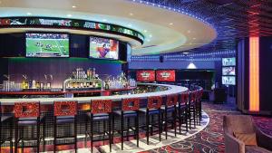 a bar with red chairs in a casino at Hard Rock Hotel & Casino Tulsa in Tulsa