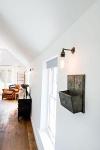 a living room with white walls and a wooden floor at The Workshop @ The Grange in Lydd