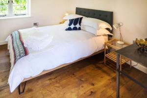 a bedroom with a large white bed with a black headboard at The Workshop @ The Grange in Lydd