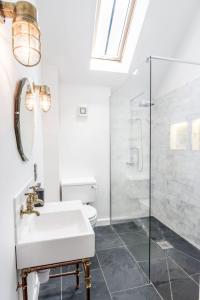 a white bathroom with a sink and a shower at The Workshop @ The Grange in Lydd