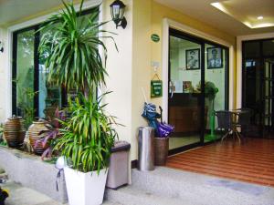 a porch with potted plants in front of a building at T.P. Place Hotel in Phangnga