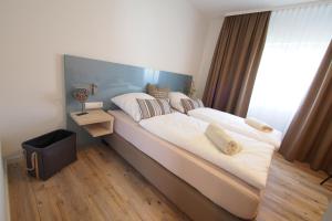 a large bed in a room with a large window at Apartments Bogner in Marktbergel