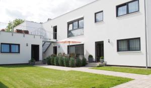 een wit huis met een groene tuin bij Apartments Bogner in Marktbergel