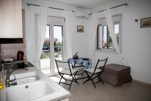 a kitchen with a table and chairs and a sink at Romanos Xi in Xi