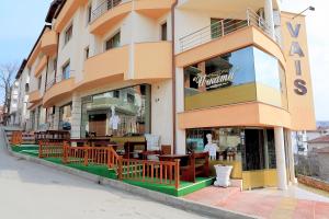 a building with tables and chairs outside of it at Къща за гости "ВАИС" in Sandanski