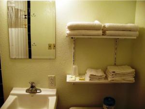 a bathroom with a sink and a mirror and towels at Golden West Motel in Klamath Falls