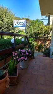 a sign for a garden with flowers on a patio at Hotel Signorini in Castiglioncello