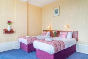 una habitación de hotel con 2 camas en una habitación en Queens Hotel, en Eastbourne