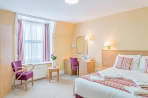 Habitación de hotel con cama y espejo en Queens Hotel, en Eastbourne