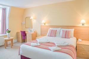 伊斯特布恩的住宿－皇后酒店，一间卧室配有一张大床和毛巾