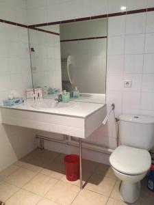 een badkamer met een wastafel, een toilet en een spiegel bij Charmant appartement - Centre d'Arcachon in Arcachon