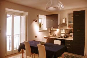 a kitchen with a black table and chairs and a kitchen with a window at Palazzo Moncada Apartment in Palermo