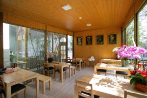 un restaurante con mesas y sillas de madera y ventanas en Xianel Vacation Chateau en Dahu