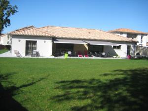 a white house with chairs and a yard at La Vertabelle in Vertou