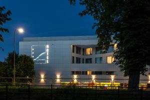 a white building with lights in front of it at Hotel Zatoka in Gdańsk