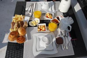 a table with breakfast foods and glasses of orange juice at Palais d'hôtes Darsor in Marrakesh