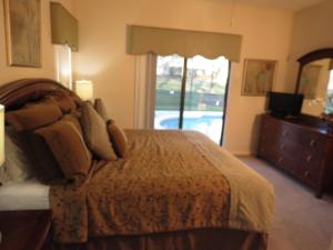 a bedroom with a bed and a large window at Kissimmee Area Pool Home in Orlando +12 photos