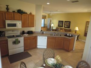 a kitchen with wooden cabinets and a table with chairs at Kissimmee Area Pool Home in Orlando
