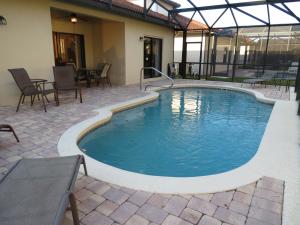 a pool in a patio with chairs and a table at Kissimmee Area Pool Home in Orlando