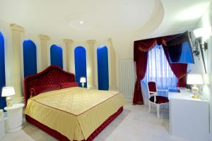 1 dormitorio con paredes azules, 1 cama y 1 silla en Design Suite Tirano en Tirano