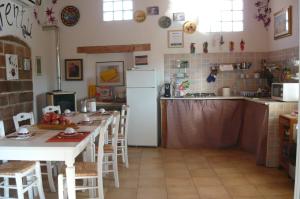 cocina con mesa y nevera en B&B Santu Larentu en Ozieri