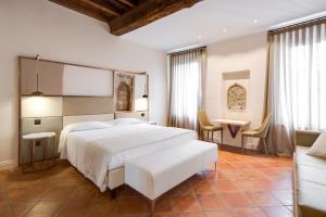 1 dormitorio con 1 cama blanca, mesa y sillas en Ferrara Rooms, en Ferrara