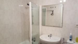 ein Badezimmer mit Dusche, Waschbecken und Spiegel in der Unterkunft Cascadas de la Marina in Denia