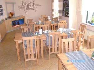 a dining room with a table and chairs and a tv at Pension Schwalbe in Zwenkau