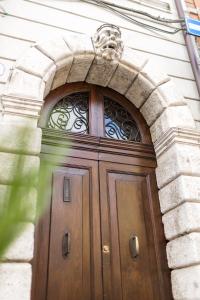 Una gran puerta de madera con un león encima. en Ferrara Rooms, en Ferrara