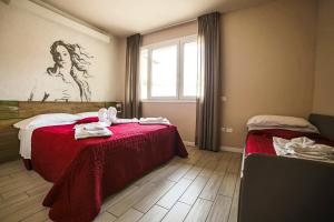 una camera con un letto con una coperta rossa e una finestra di B&B Santa Maria Novella a Firenze