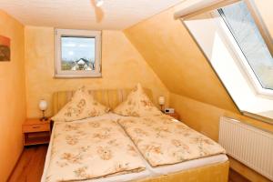 a bed in a small room with a window at Meeresrauschen in Kägsdorf