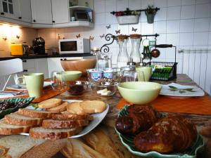 uma mesa com pão e bolos na cozinha em In Giardino B&B em Cassina deʼ Pecchi