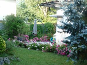 a garden with an umbrella and some flowers at Maison MARYSA in Mérignac