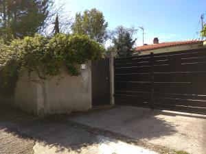 a black fence with a gate and a driveway at Maison MARYSA in Mérignac +2 photos