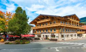 duży drewniany budynek po stronie ulicy w obiekcie Hotel Rosner w mieście Altenmarkt im Pongau