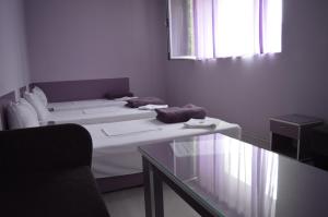 um quarto com duas camas e uma mesa de vidro em Hotel Sianie em Tutrakan