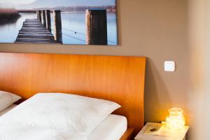 a bed with a wooden headboard with a picture of a pier at Hinterlechnerhof in Rimsting