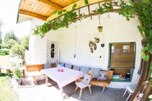 a patio with a white table and chairs at Hinterlechnerhof in Rimsting