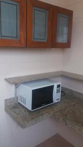 a microwave sitting on a counter in a kitchen at Flat Oeste La Residence in Goiânia