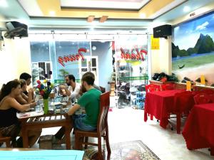 a group of people sitting at a table in a restaurant at Thanh Trung Hotel in Cat Ba