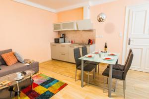 een keuken en een woonkamer met een tafel en een bank bij Titaru House in Boedapest