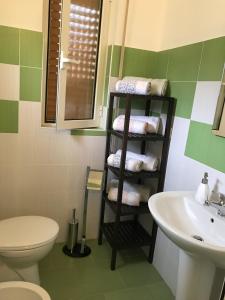 a bathroom with a sink and a shelf with towels at Appartamento Alessandra in Finale Ligure