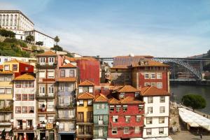un groupe de bâtiments avec un pont en arrière-plan dans l'établissement Oca Ribeira do Porto Hotel, à Porto