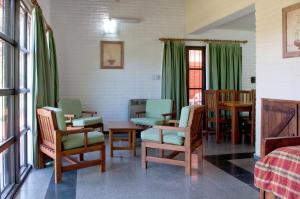una stanza con sedie, tavolo e letto di Green House a Villa General Belgrano