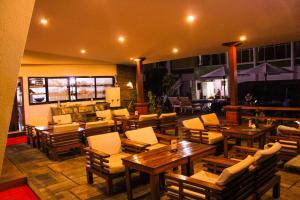 an outdoor restaurant with wooden tables and chairs at Hotel Woodland Kathmandu in Kathmandu